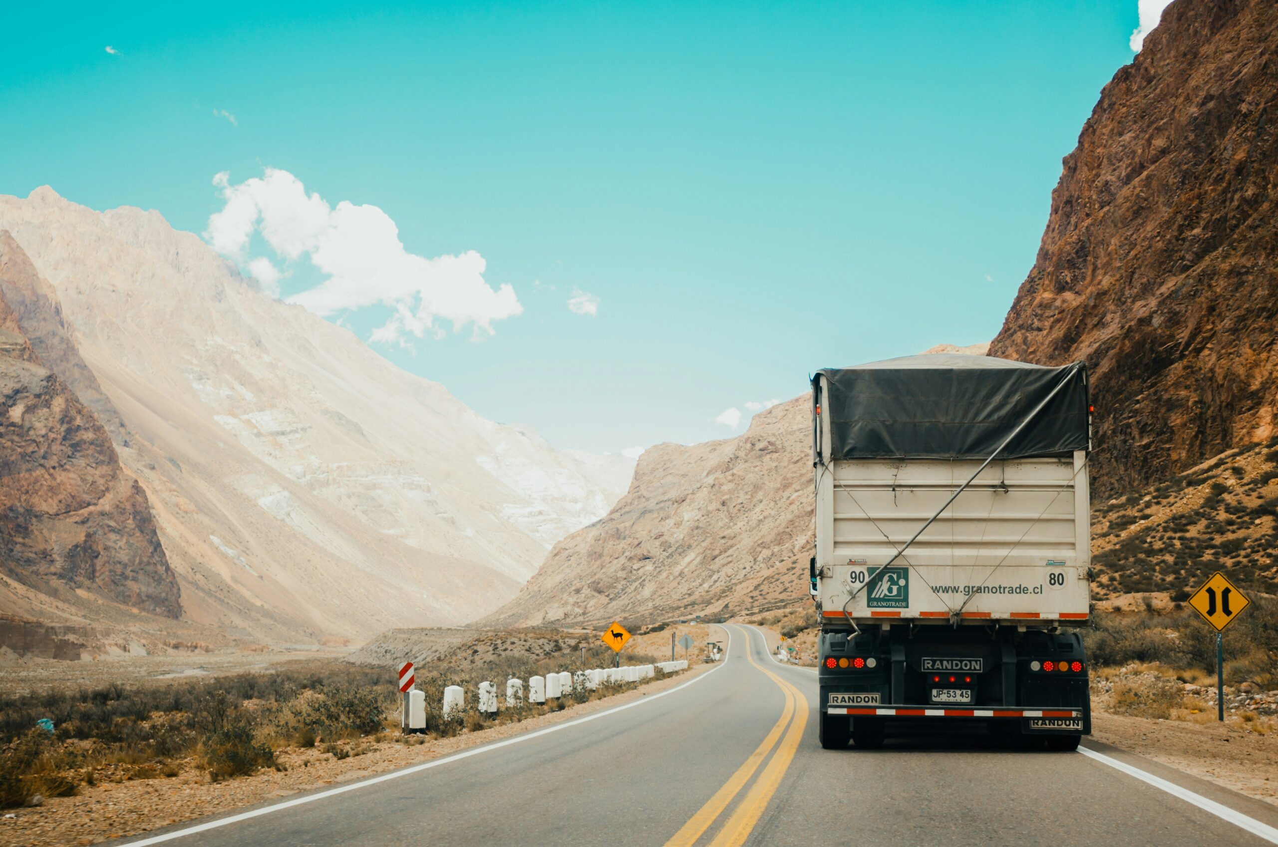 semi truck on mountain highway representing owner operator vs company driver pay comparison in 2026