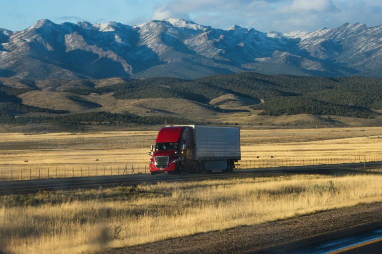 semi truck on open highway with mountains in background representing how to become an owner operator
