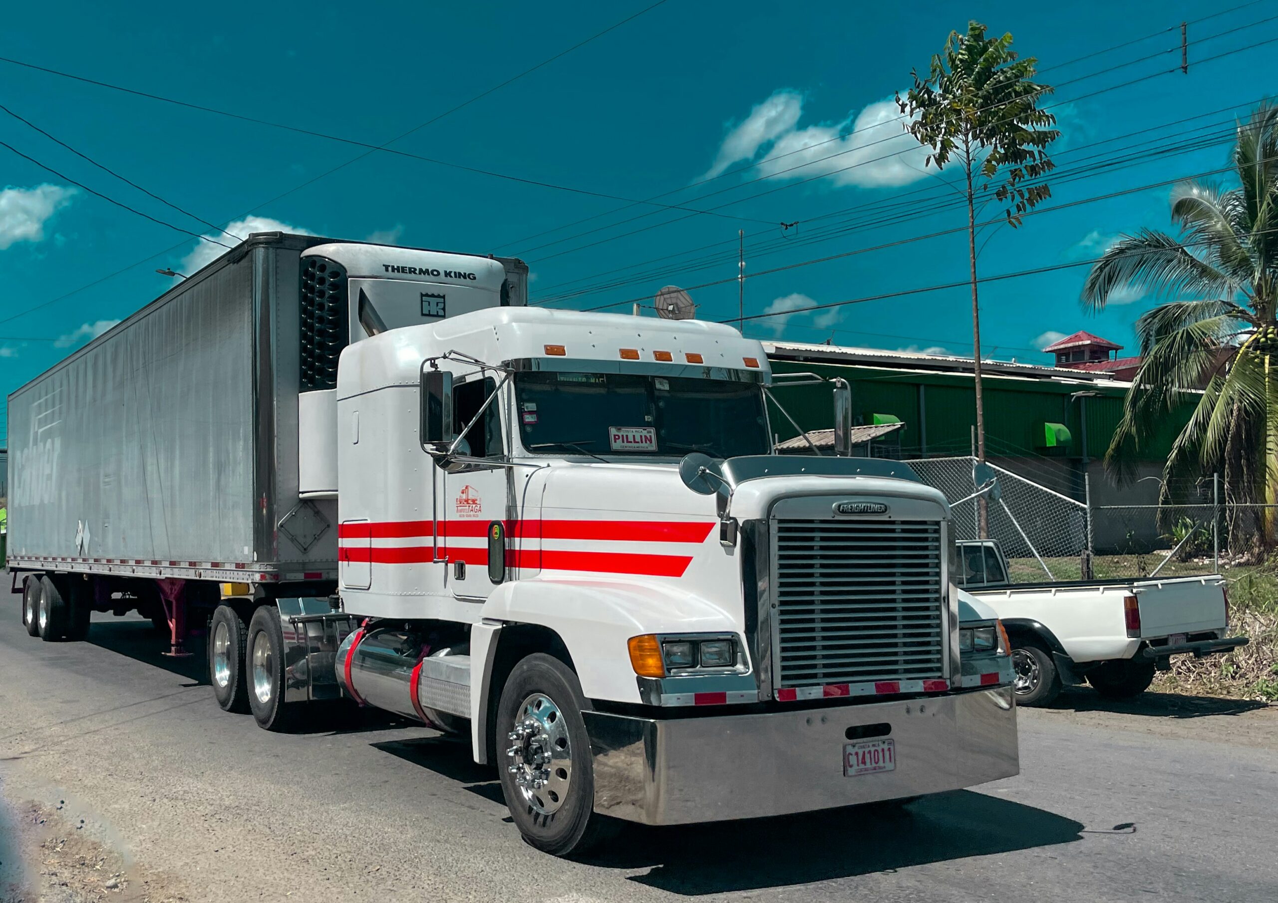 White Freightliner semi truck at truck stop — owner operator truck insurance costs and coverage guide