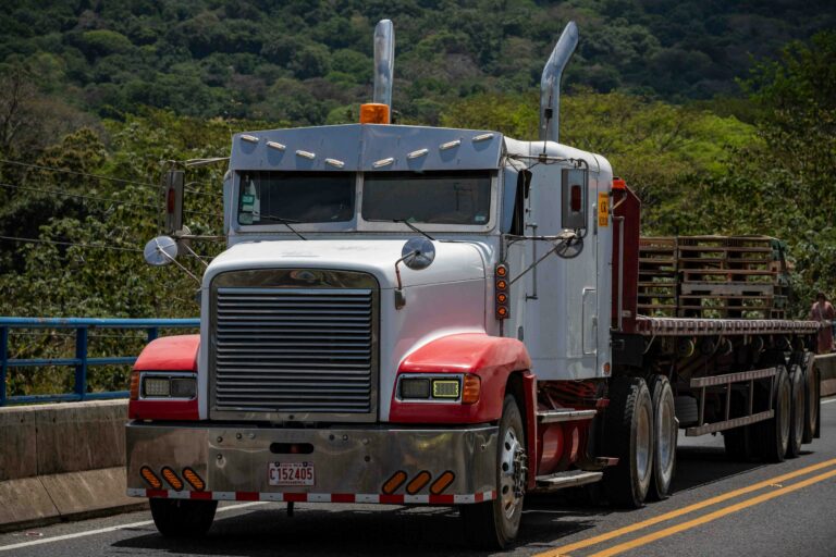 Red semi truck on highway — freight factoring for owner operators guide