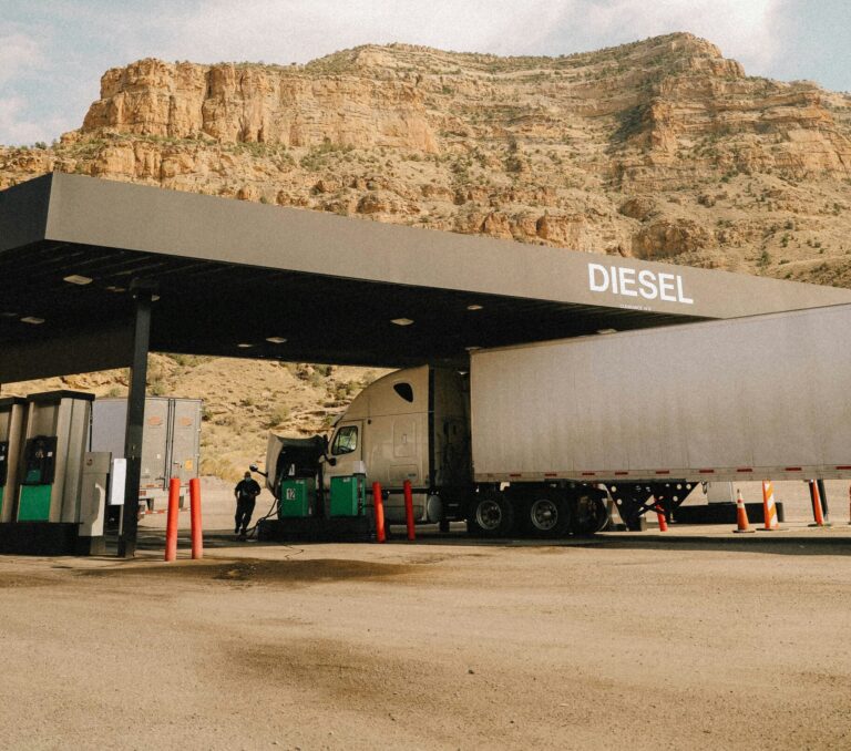 Semi truck at fuel stop with mountain backdrop — semi truck fuel cost guide