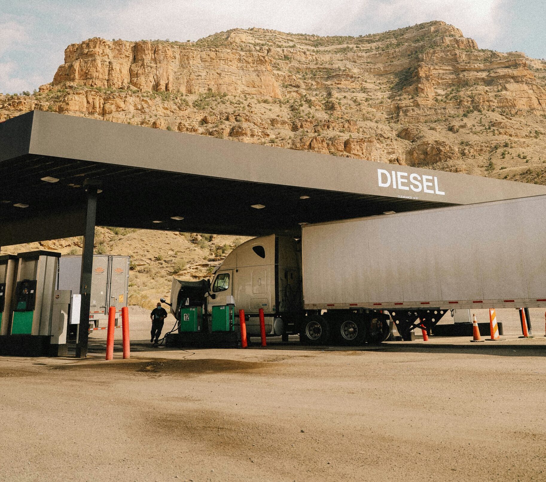 Semi truck at fuel stop with mountain backdrop — semi truck fuel cost guide