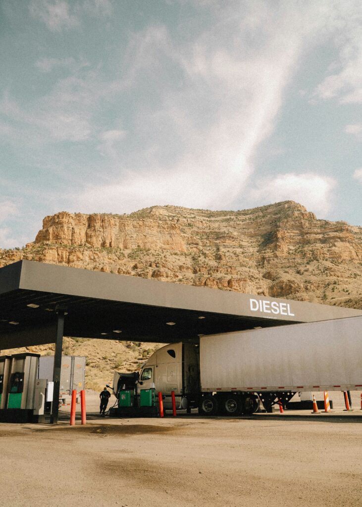 Semi truck at fuel stop with mountain backdrop — semi truck fuel cost guide