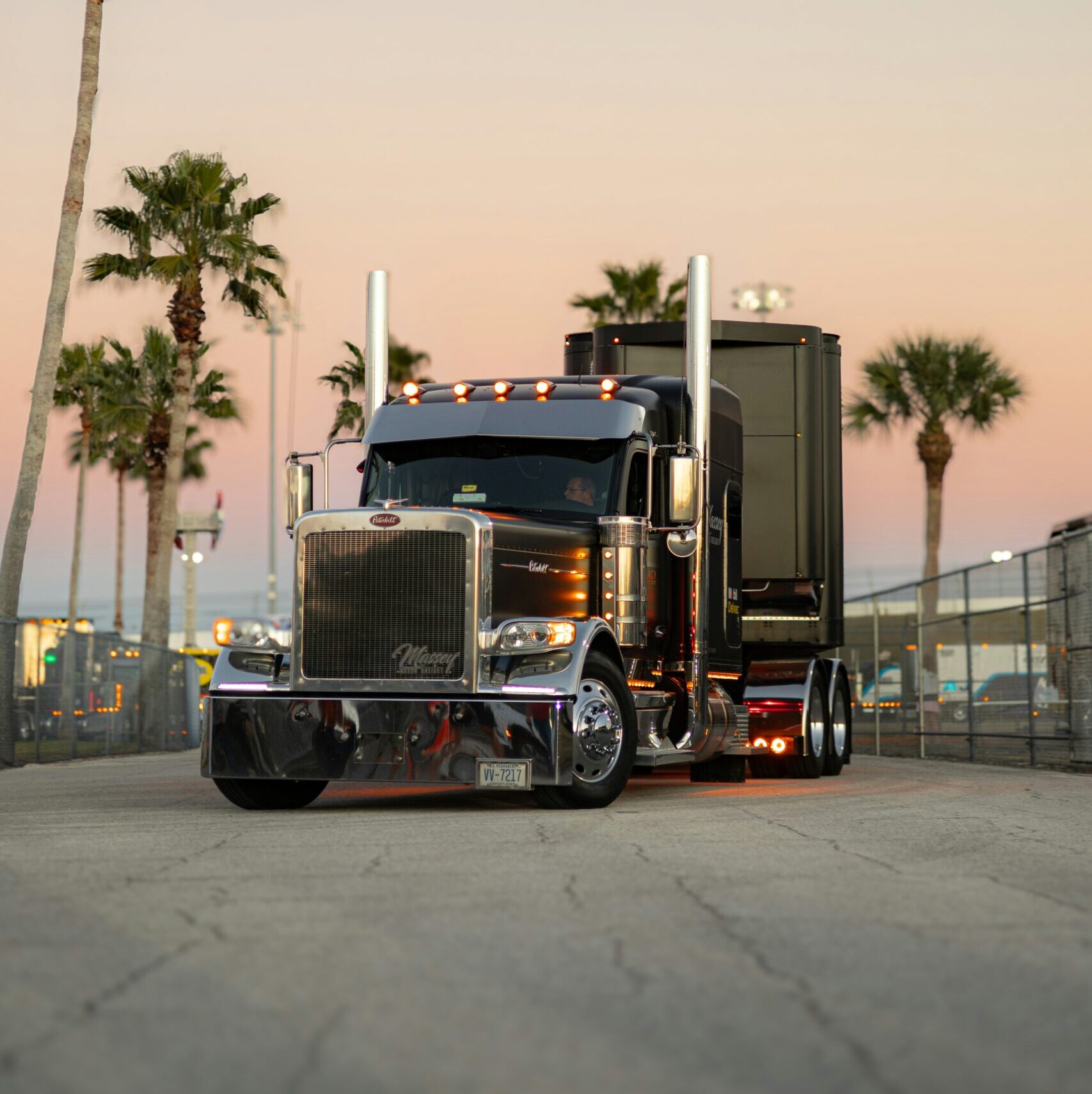 Black semi truck driving at dusk on open highway — owner operator pay guide 2026