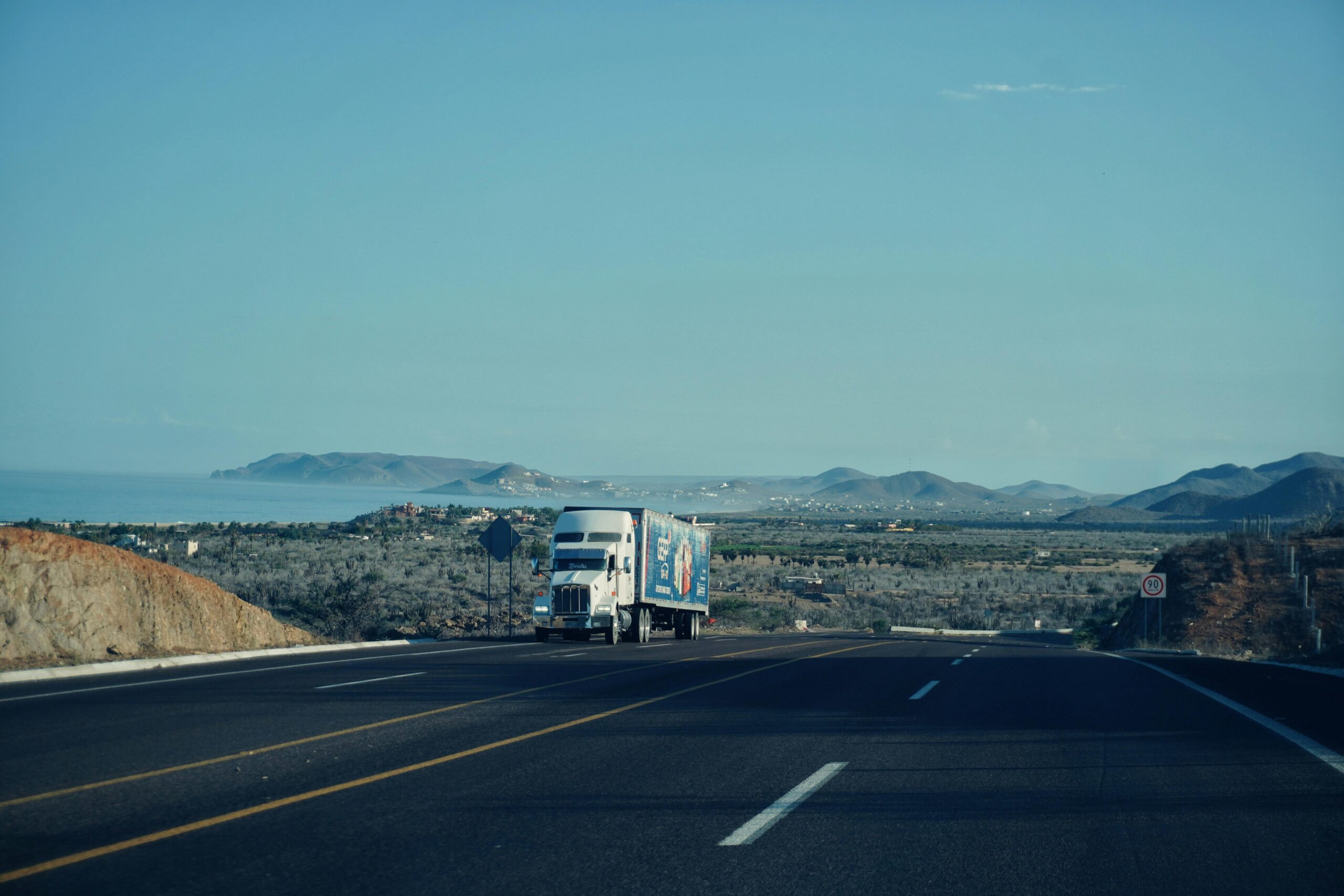 Trucker driving a semi on an open highway — free daily log template for drivers