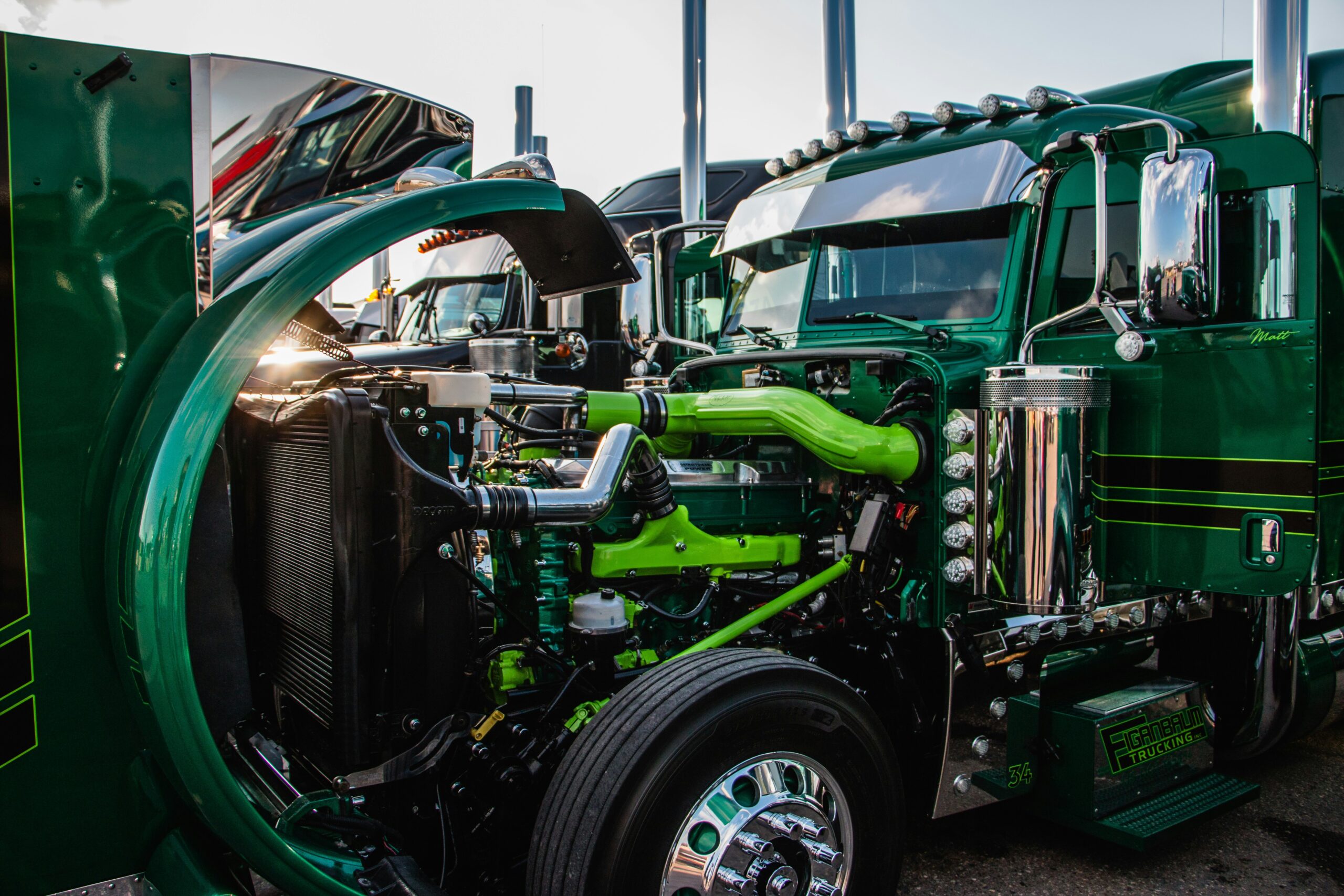 Green and black semi truck engines close up — semi truck maintenance costs guide for owner operators
