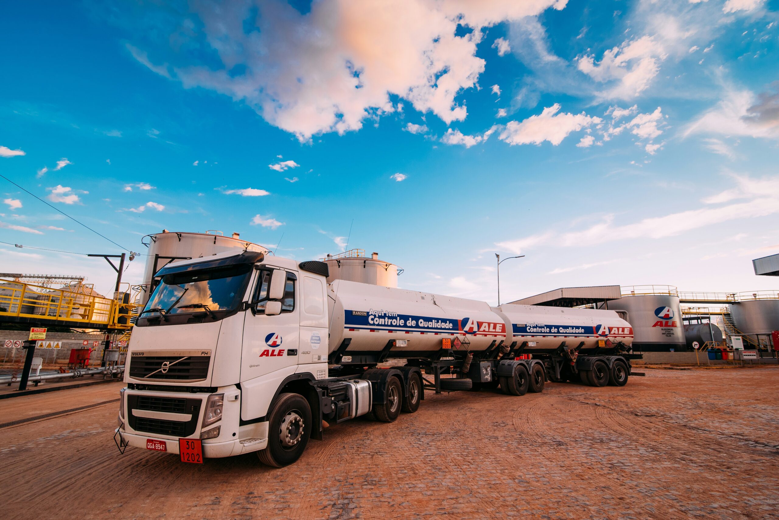Flatbed semi-trucks parked in a lot, representing owner-operators calculating fuel cost per mile